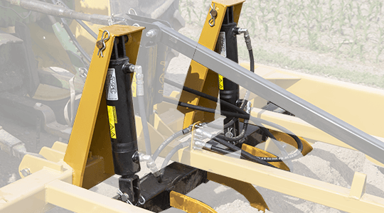 Two hydraulic cylinders power the scarifier bar deep below the surface loosening the hard pan and pulling the material to the surface where it can be redistributed.
